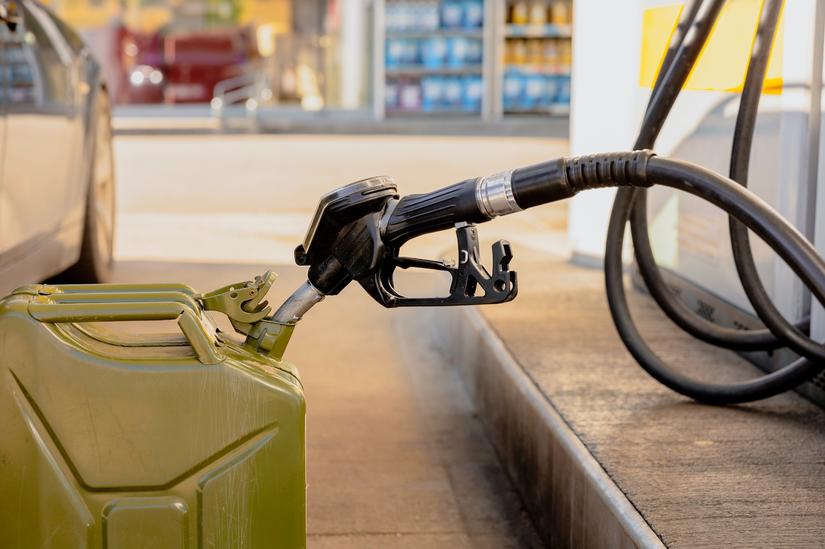 Mobile Fuel Delivery service refilling green jerry can with gasoline at a petrol station for portable fuel storage.